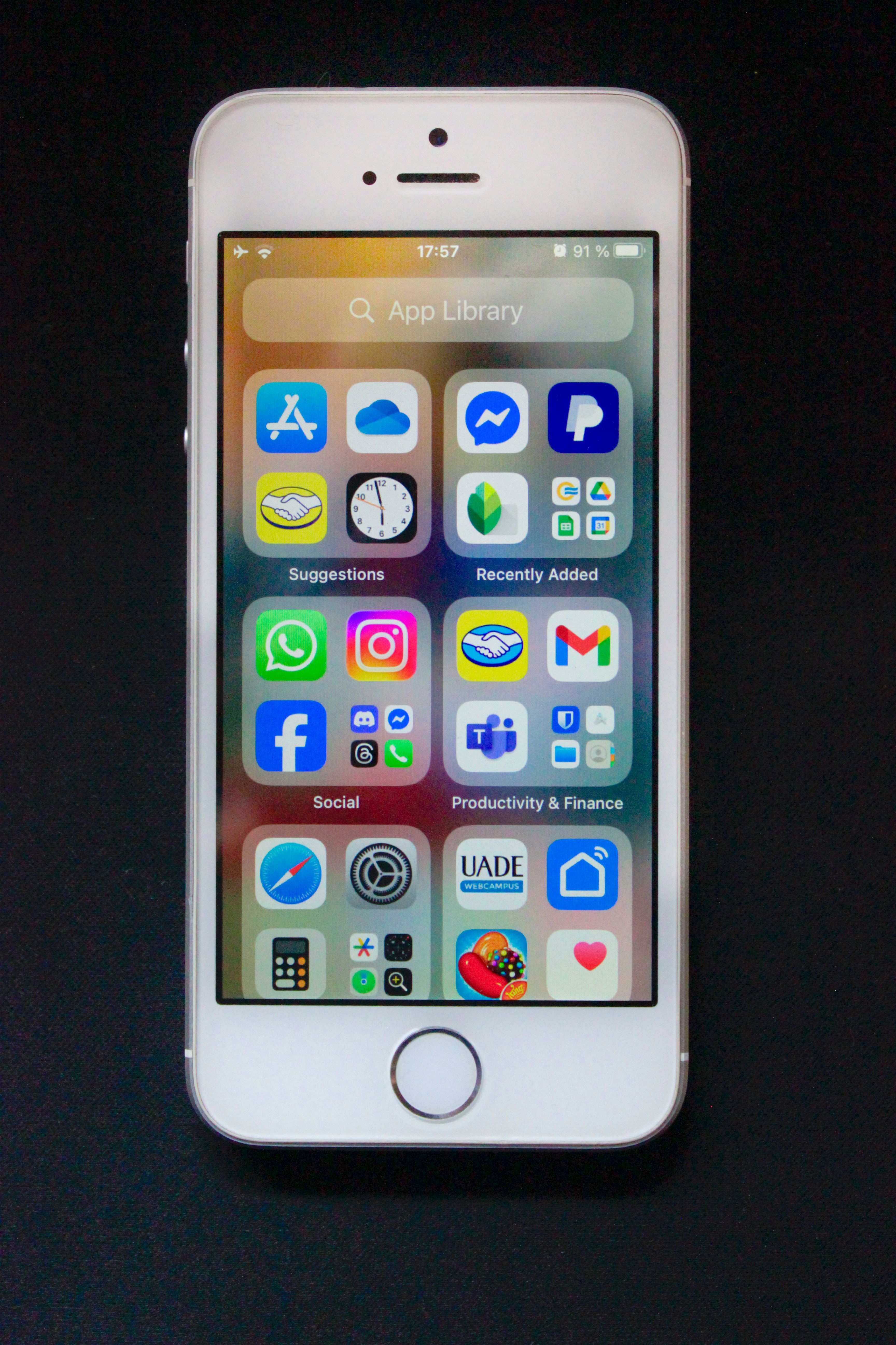 En iPhone med app-biblioteket öppet, uppdelat i mappar som Suggestions, Recently Added, Social och Productivity &amp;amp; Finance, med appar som WhatsApp, Instagram, Facebook och Discord synliga
